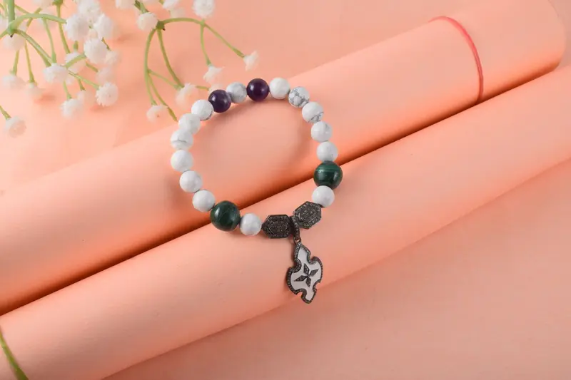 A stylish beaded bracelet with a decorative charm on a pastel background, perfect for fashion themes