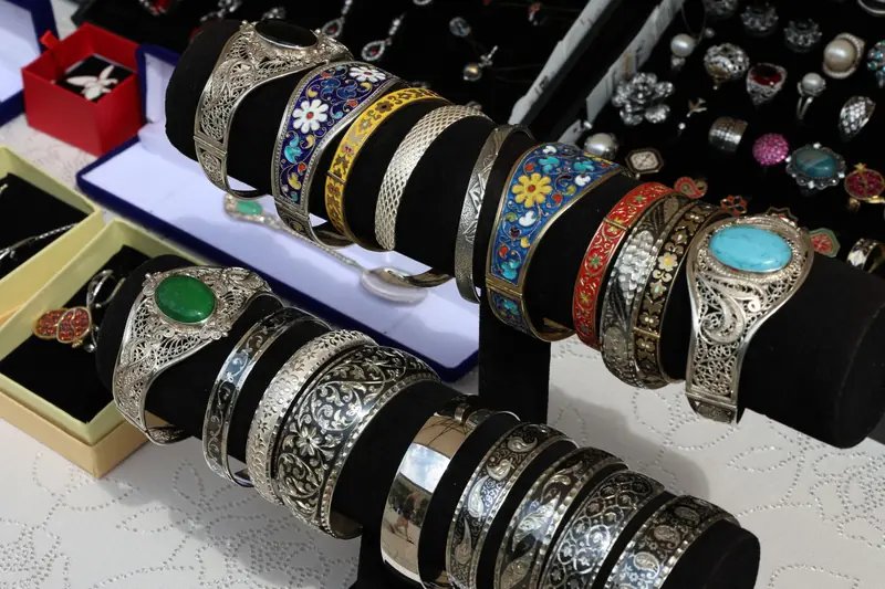 Colorful and intricate silver bracelets on display at a jewelry market stall, showcasing craftsmanship