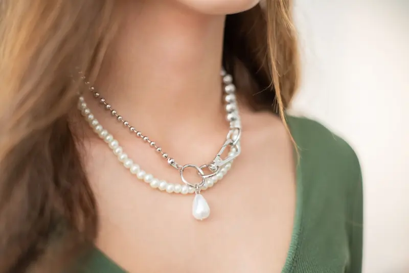 Close-up of a woman's neck adorned with elegant layered pearl necklaces