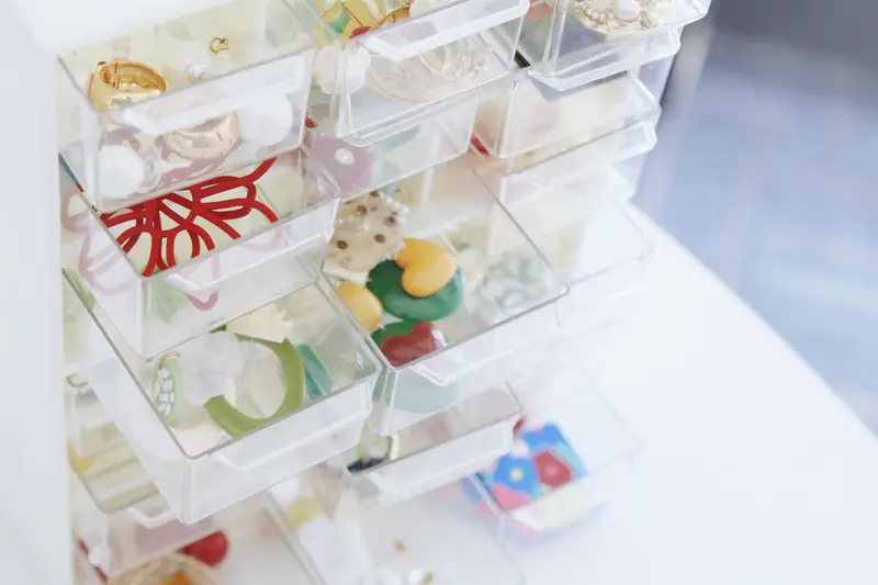 A collection of colorful jewelry pieces organized in transparent storage drawers