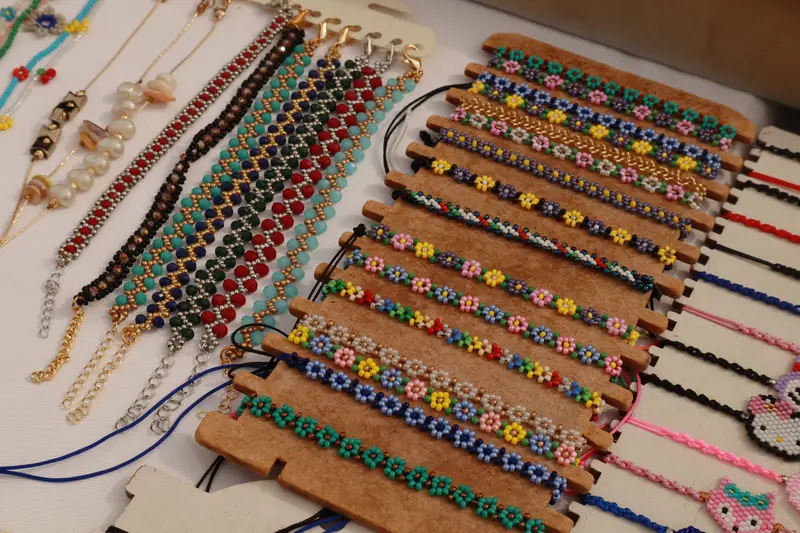 A variety of colorful handmade beaded bracelets on display at a market stall