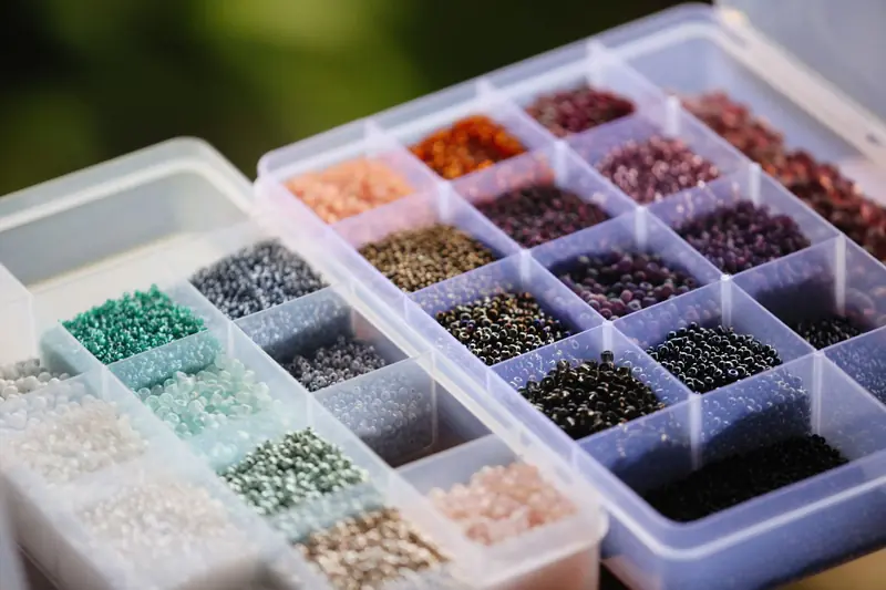 A close-up of a variety of colorful beads arranged in an organizer box, ideal for craft and jewelry making