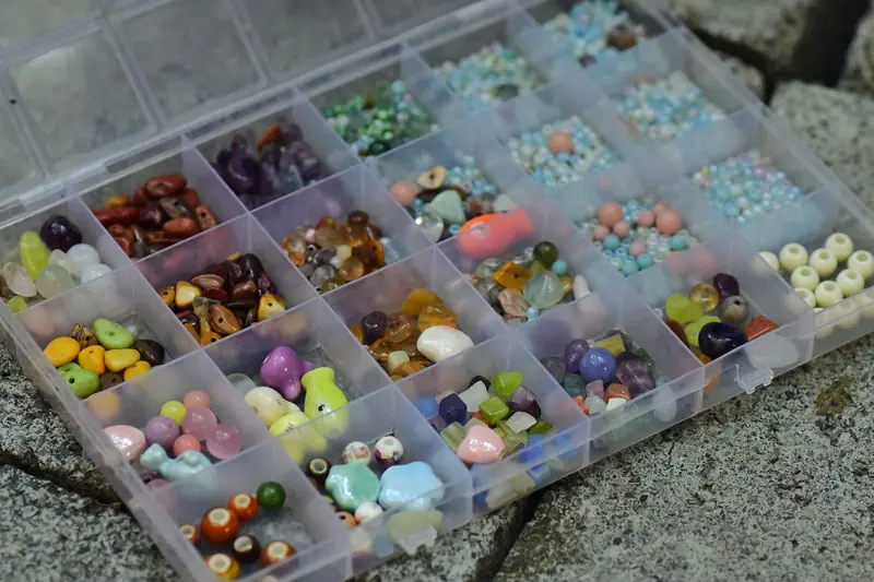 Top view of a transparent storage box filled with colorful assorted beads for crafts and jewelry making