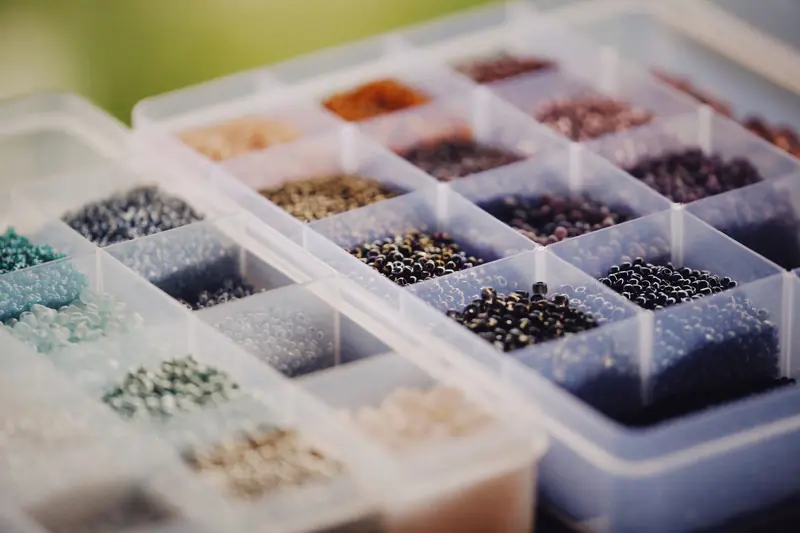 Vibrant beads sorted by color in a plastic container, perfect for crafting and jewelry making